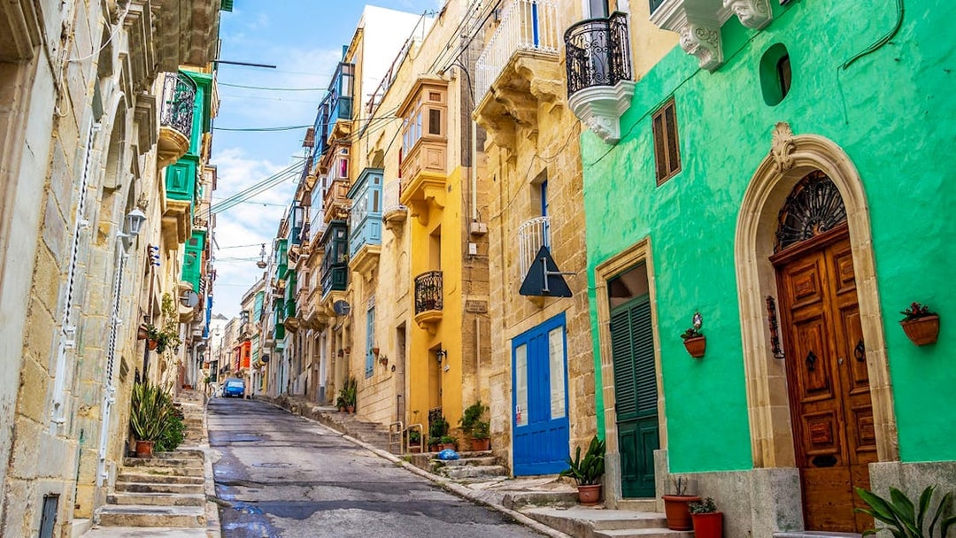 Colorful street in Valletta with traditional Maltese balconies, part of the Half-Day Guided Tour.