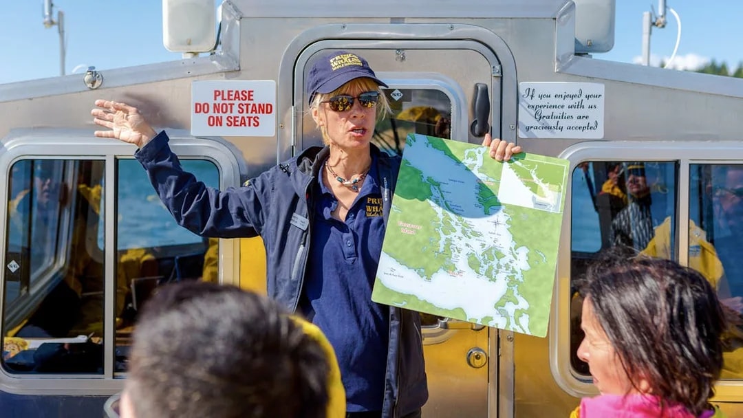 Guide explaining boat tour route with map in hand, Vancouver Island.