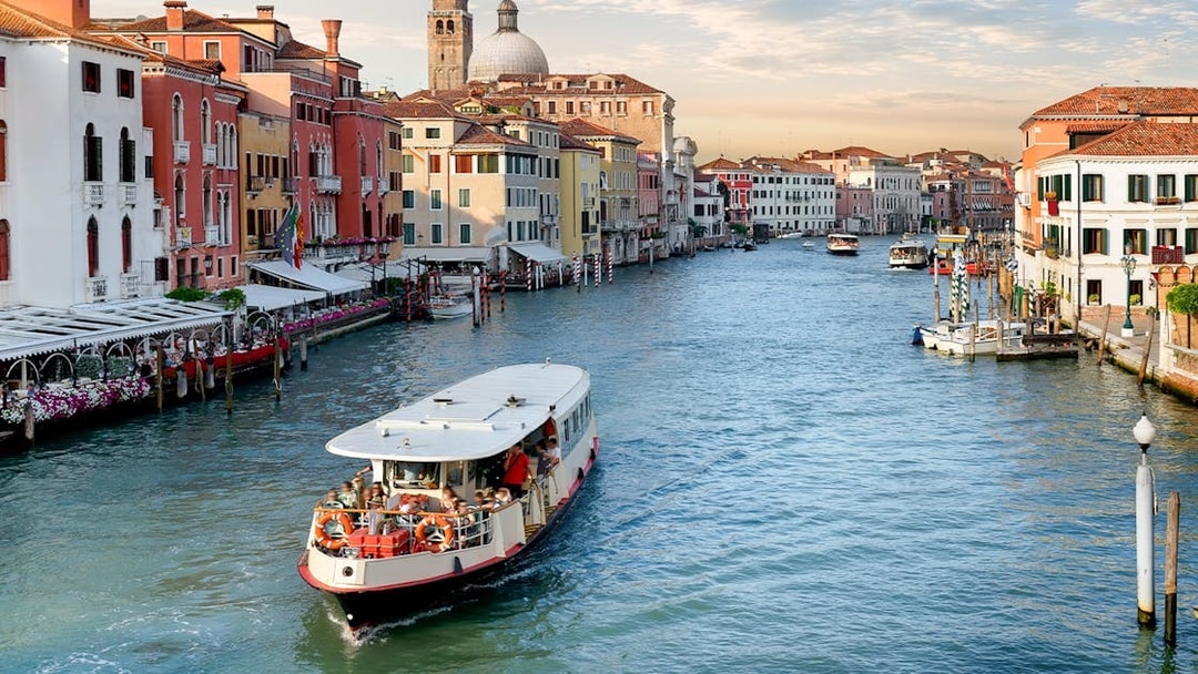 Vaporetto cruising on the Grand Canal in Venice with colorful buildings in the background.
