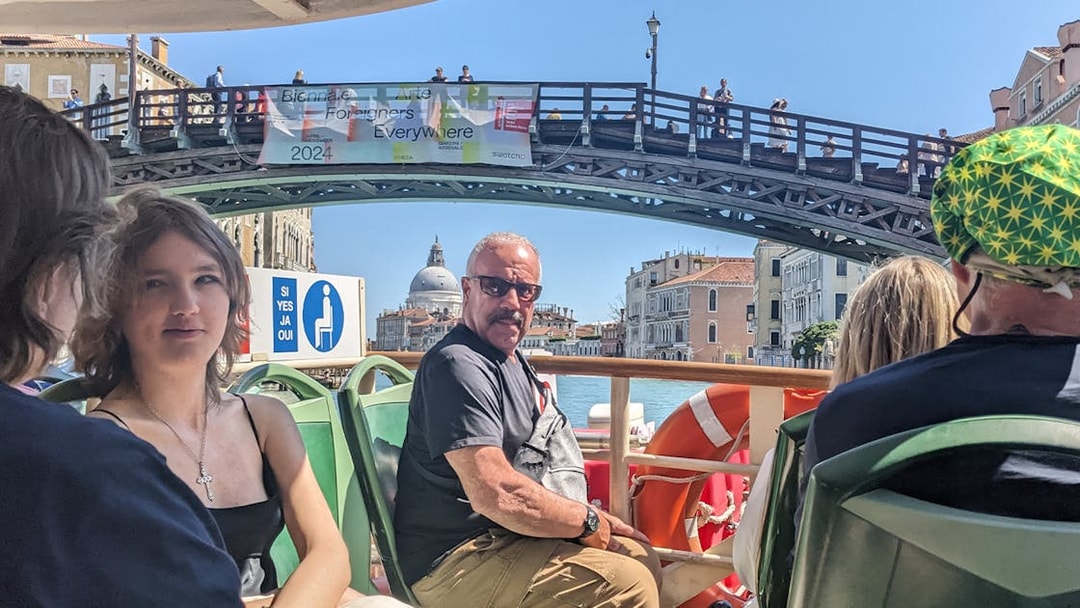 Passengers on Venice ACTV water bus with view of Ponte dell'Accademia and Santa Maria della Salute.