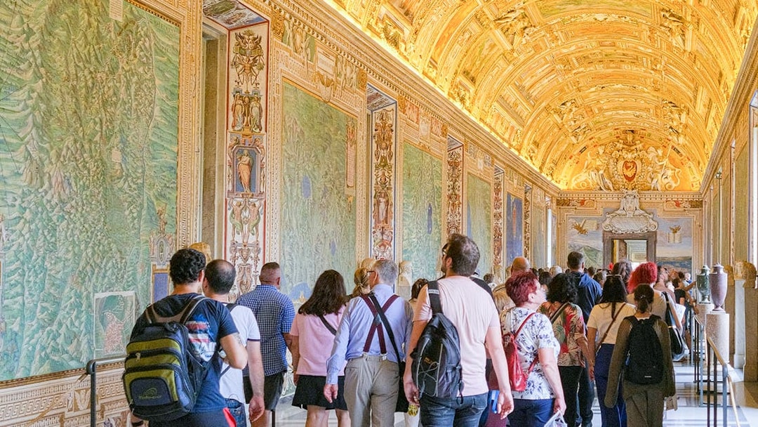Visitors exploring the ornate Gallery of Maps in the Vatican Museums.