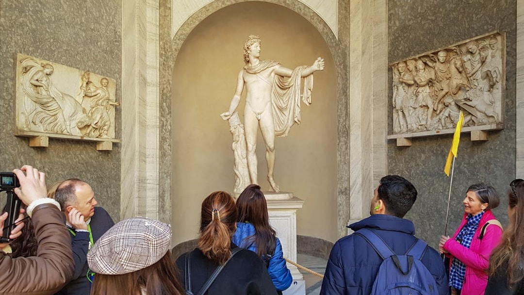 Tourists with guide near Statue of Apollo Belvedere, Vatican Museum.