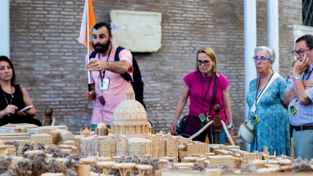 Tour group examining Vatican model at Vatican Museums, Rome.