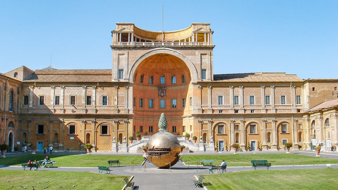 Tourists in Vatican Museums courtyard with Sphere Within Sphere sculpture, Rome, Italy.