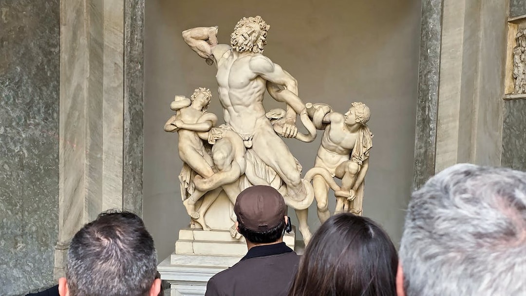 Visitors viewing Laocoön and His Sons sculpture at Vatican Museums.