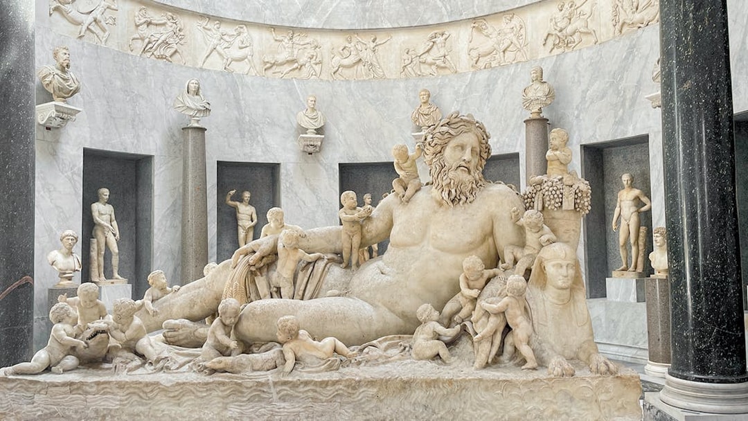 Statue of river god Oceanus surrounded by figures in Vatican Museums.