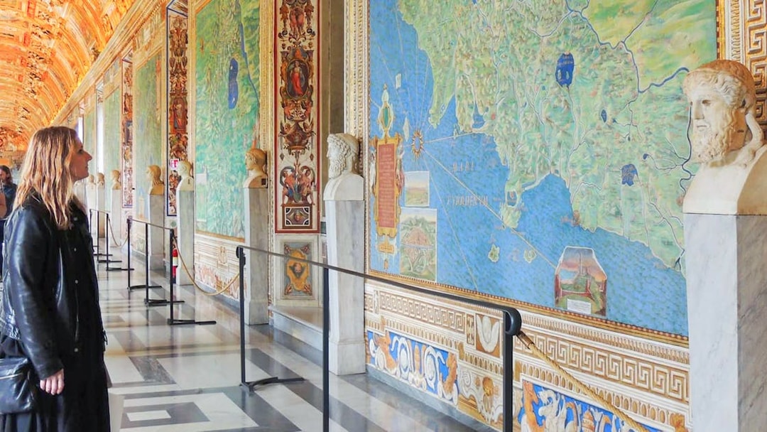 Visitor admiring detailed frescoes in the Vatican Gallery of Maps, Vatican City.