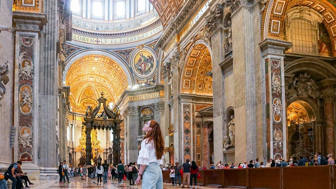 Visitor admiring the ornate interior of St. Peter's Basilica, Vatican City.