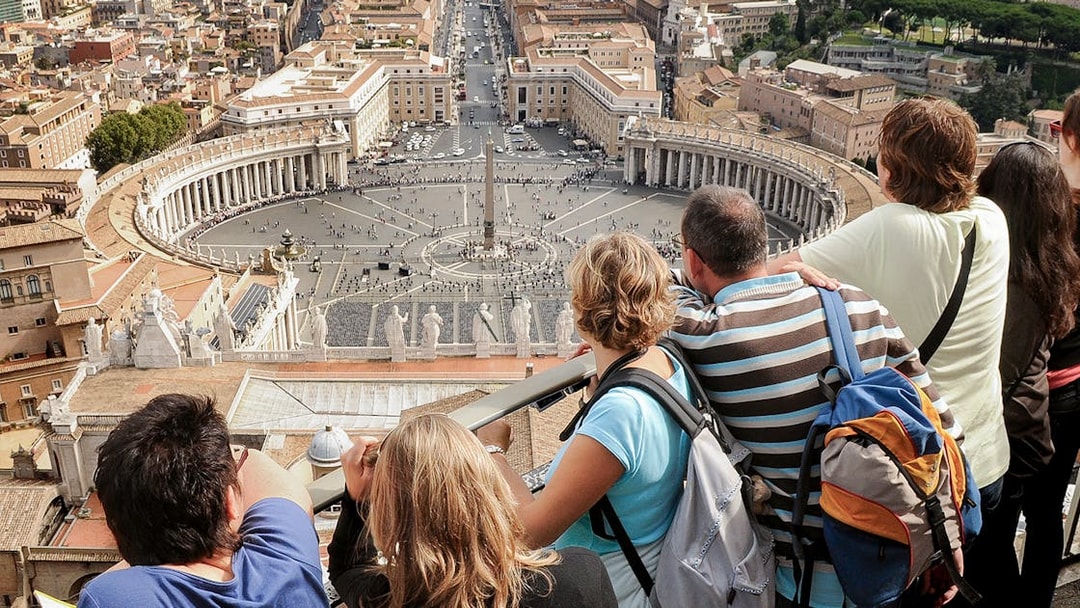 Visitors overlooking St. Peter’s Square from the Basilica Dome Terrace in Vatican City.
