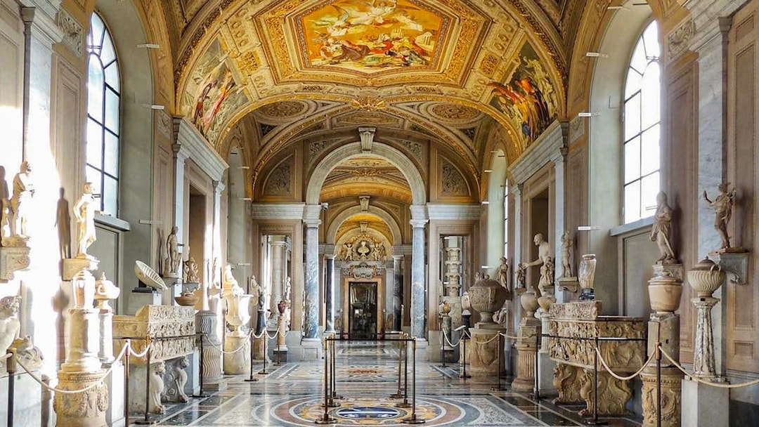 Vatican Museum Gallery with sculptures and ornate ceiling.