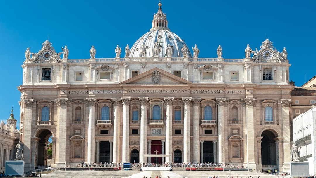 Facade of St. Peter’s Basilica in Vatican City with statues and columns.
