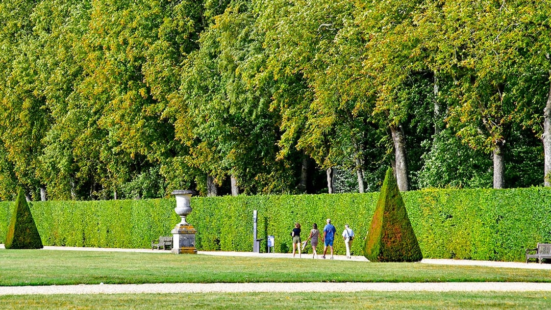 Visitors walking through the gardens of Château of Vaux-le-Vicomte, France.