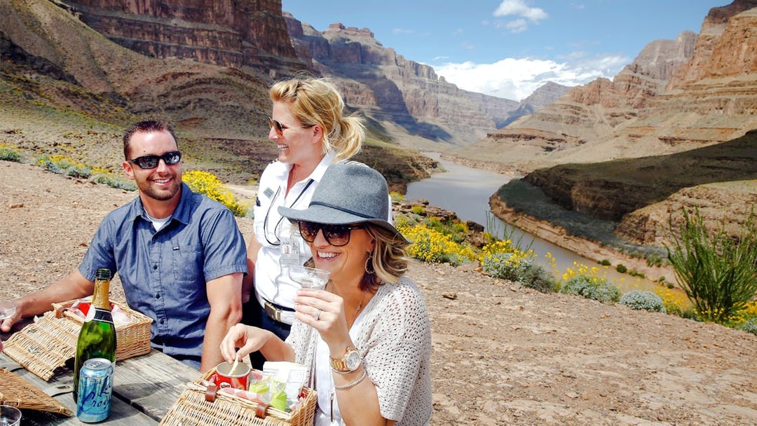 Guests enjoying snacks and champagne on the Grand Canyon floor with scenic views.