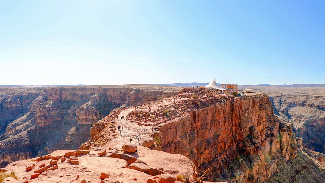Grand Canyon West Rim with visitors walking along the cliff edge, seen from a helicopter tour.