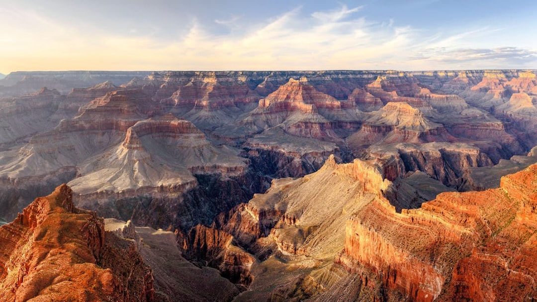 Grand Canyon panoramic view with layered rock formations under a clear sky.