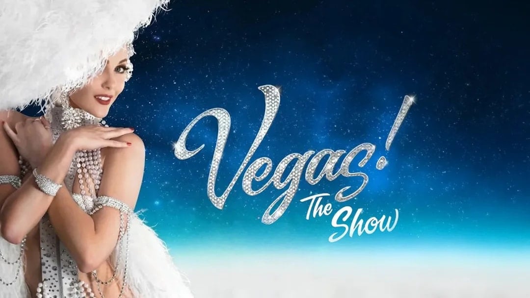 Showgirl in feathered costume with "Vegas! The Show" text on starry background.