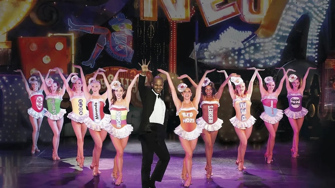 Performers in candy-themed costumes on stage at VEGAS! The Show.