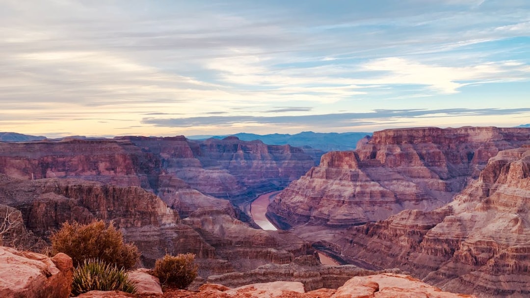 Grand Canyon view with layered rock formations and Colorado River below.