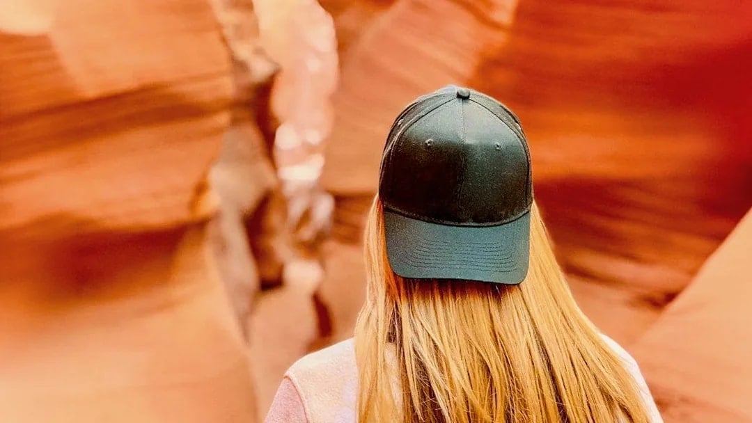 Visitor exploring the narrow sandstone walls of Lower Antelope Canyon.