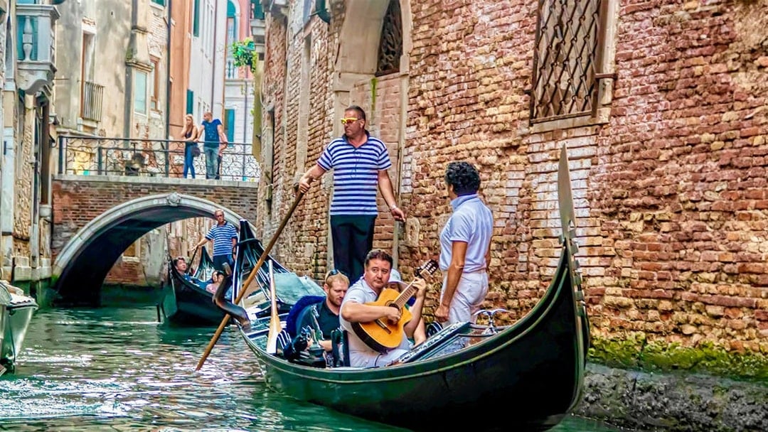 Gondola ride with musician serenading in Venice canal.
