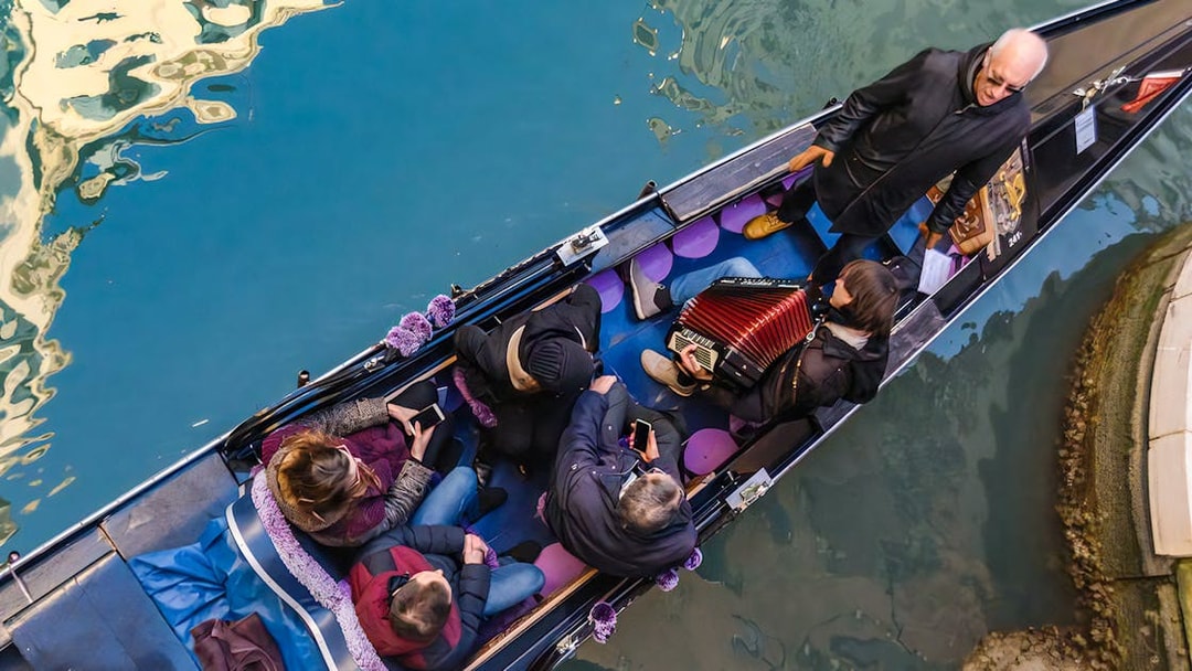 Gondola ride in Venice with musician playing accordion and passengers enjoying the serenade.