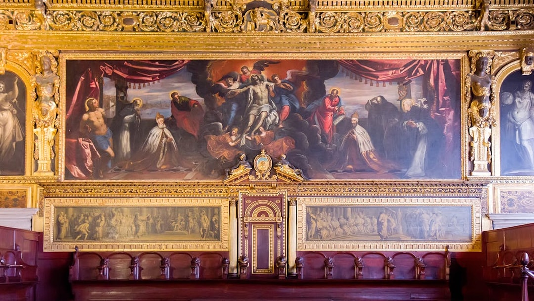 Doge Palace chamber with ornate gold detailing and historical paintings in Venice.
