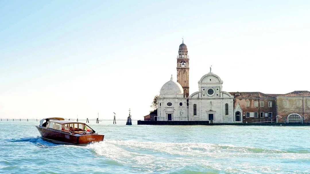 Water taxi near San Michele Island, Venice, with church in background.