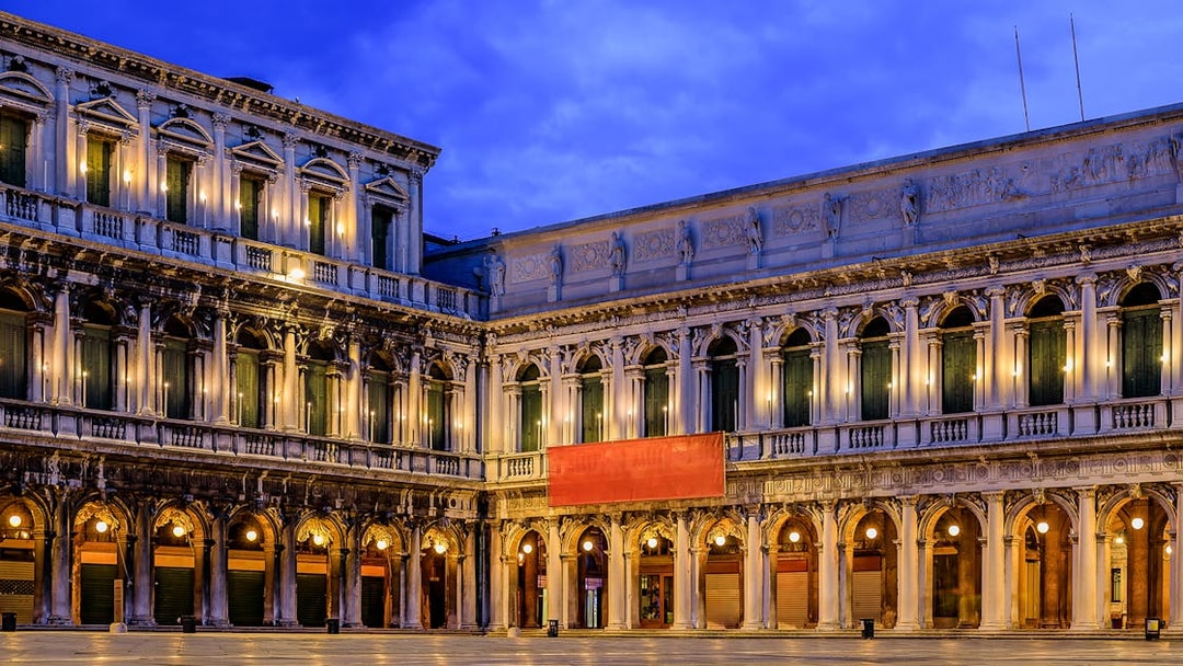 Venice's Museo Correr facade illuminated at dusk, part of the Venice Museums Pass.