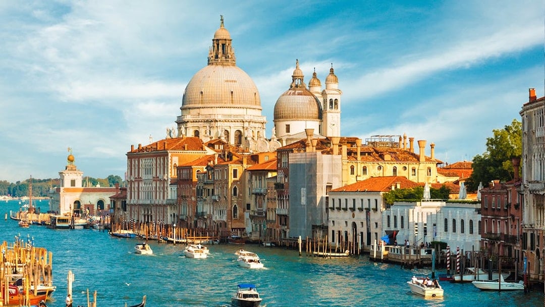 Grand Canal with Santa Maria della Salute in Venice, Italy, featuring gondolas and boats.
