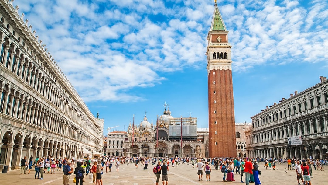 St. Mark's Square with Campanile and Basilica in Venice, Italy, crowded with tourists.