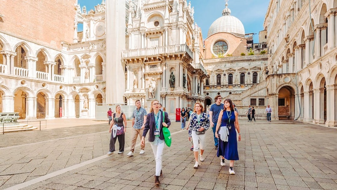 Visitors exploring the courtyard of Doge's Palace on a guided tour in Venice.