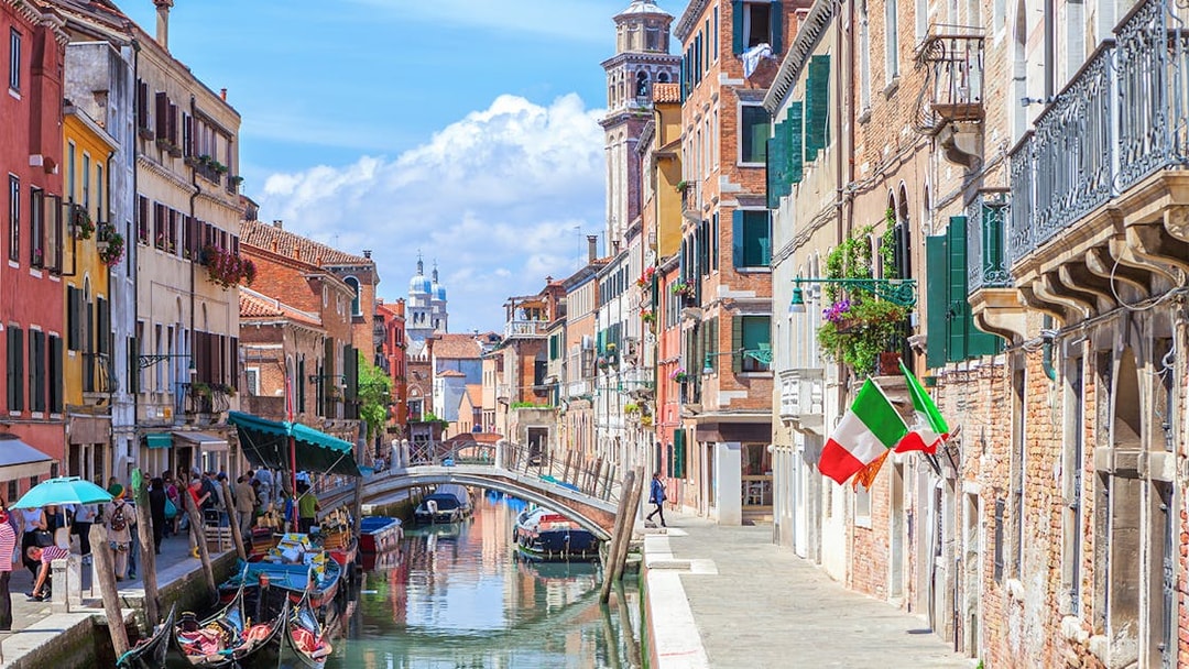 Venice canal with gondolas and colorful buildings on a walking tour route.
