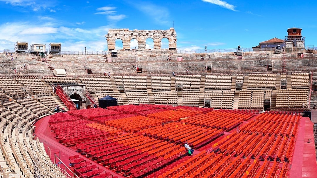 Verona Arena Italy with tourists exploring ancient Roman amphitheater architecture.