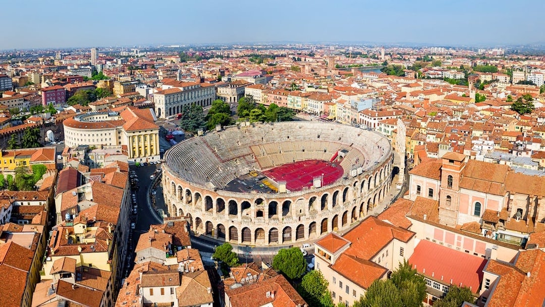 Aerial view of the Verona Arena surrounded by historic buildings in Verona, Italy.