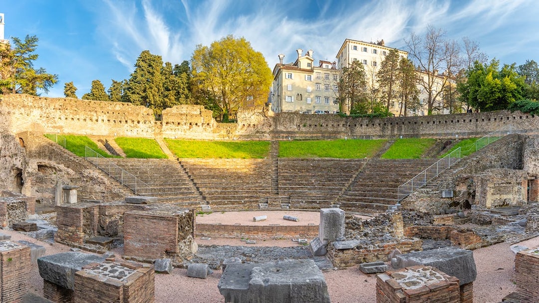 Ancient Roman amphitheater in Verona with stone ruins and tiered seating.