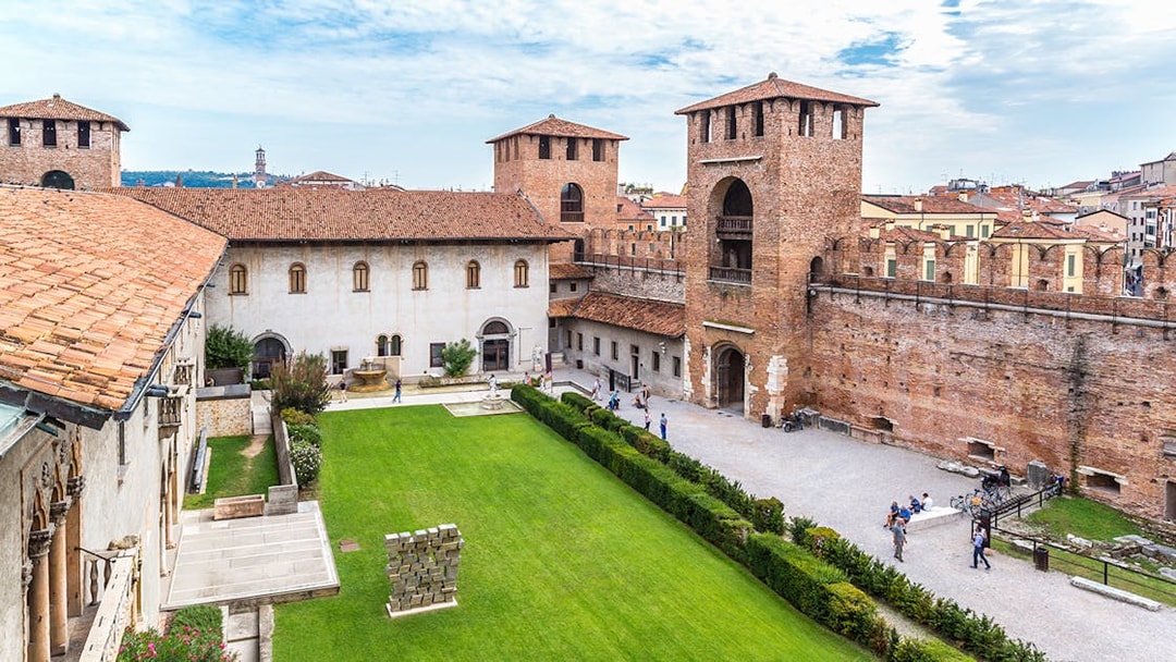 Castelvecchio Museum courtyard with historic walls and green lawn in Verona.