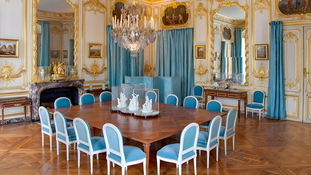 Versailles King's Private Apartment Porcelain Dining Room with ornate decor and blue chairs.