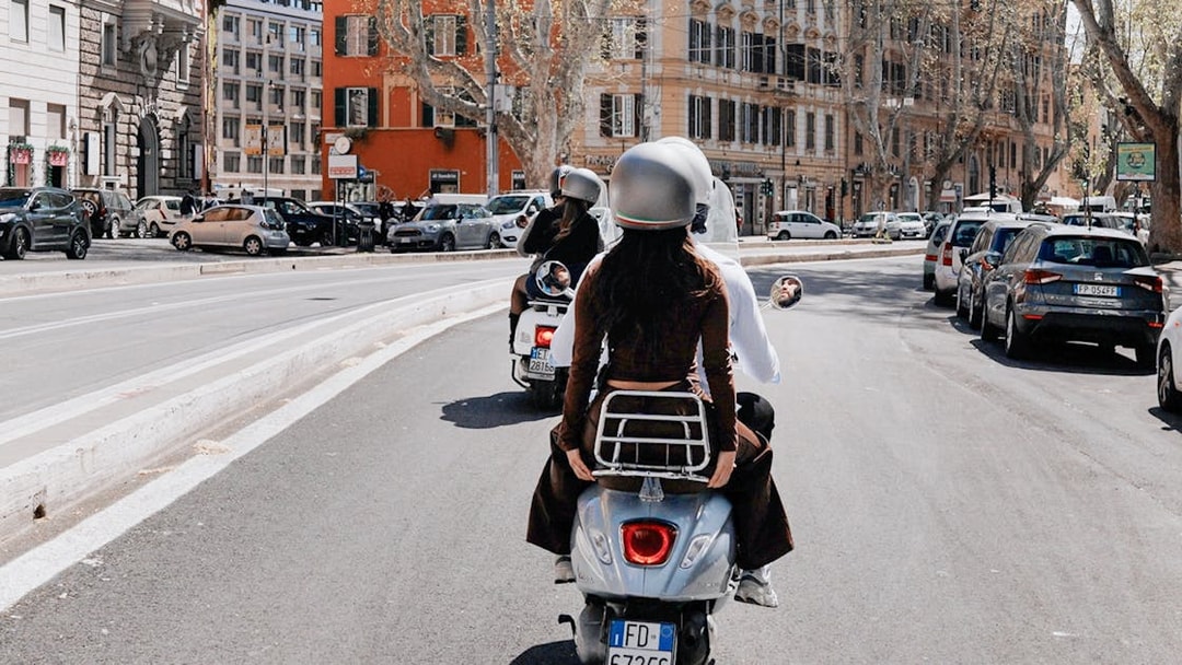 Tourists riding Vespas on a street in Rome, Italy.