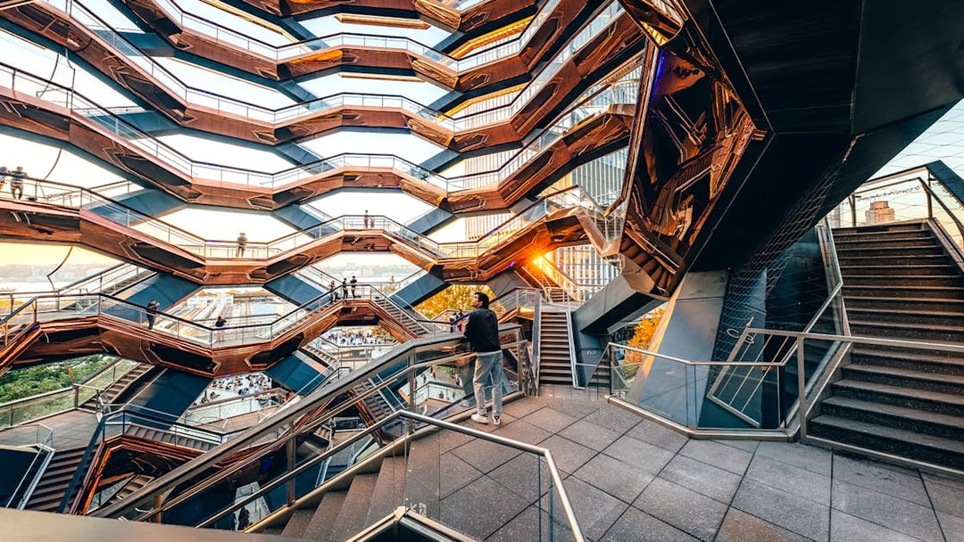Vessel structure with visitors on staircases at sunset, New York City.