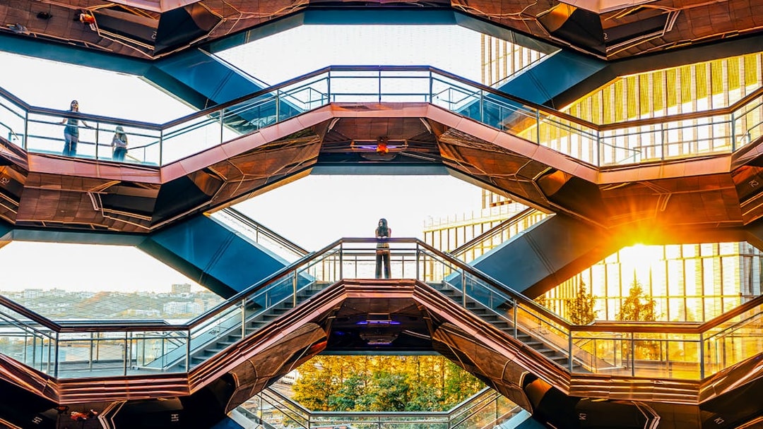 Vessel structure in New York City with visitors on staircases at sunset.