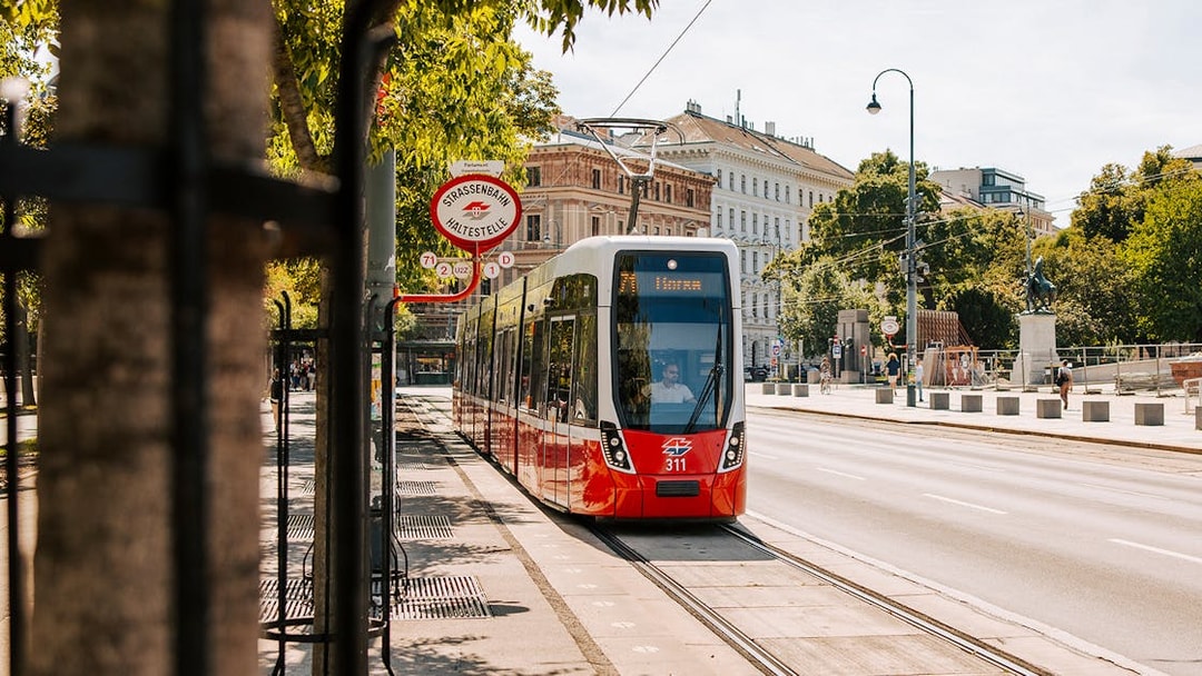 Tram on Vienna street near historic buildings, part of Vienna City Card benefits.