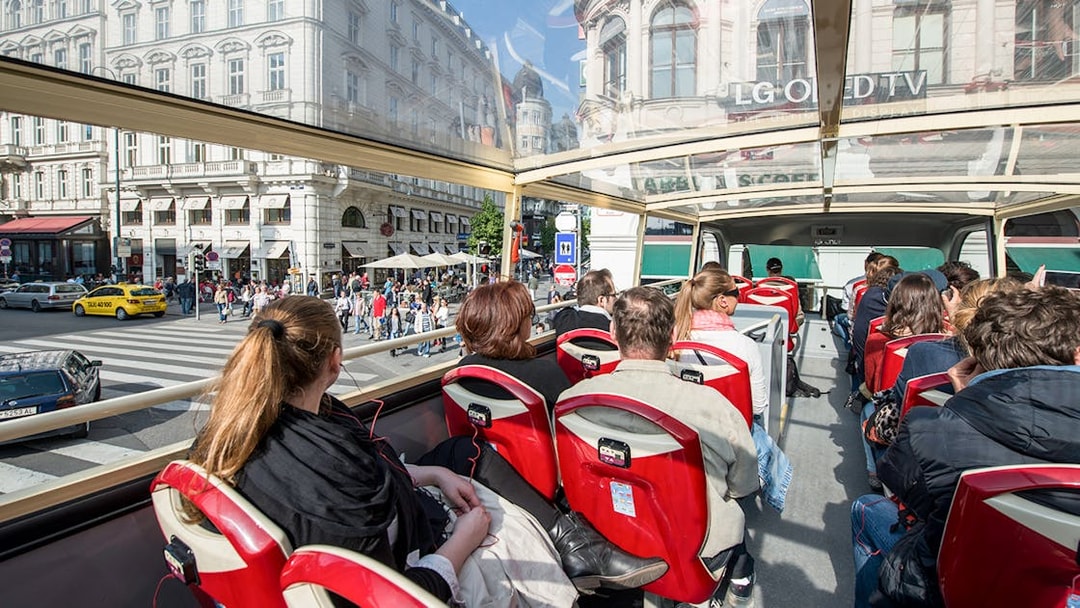 Passengers on a Vienna Hop-On Hop-Off bus touring city streets.
