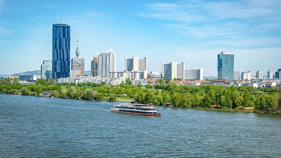 Cruise ship on the Danube River with Vienna skyline in the background.