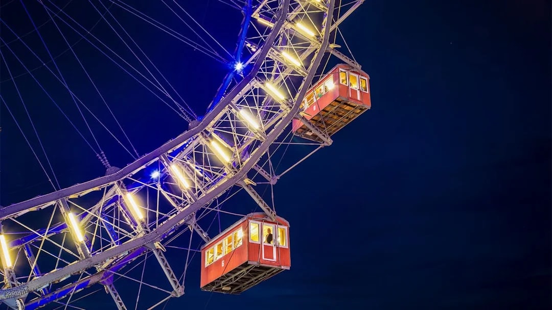 Cabins of the Giant Ferris Wheel in Vienna illuminated at night.