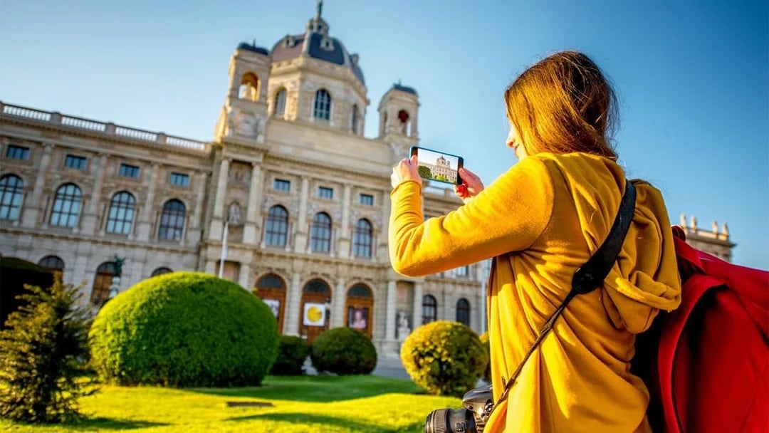 Visitor photographing the Kunsthistorisches Museum in Vienna during a self-guided audio tour.