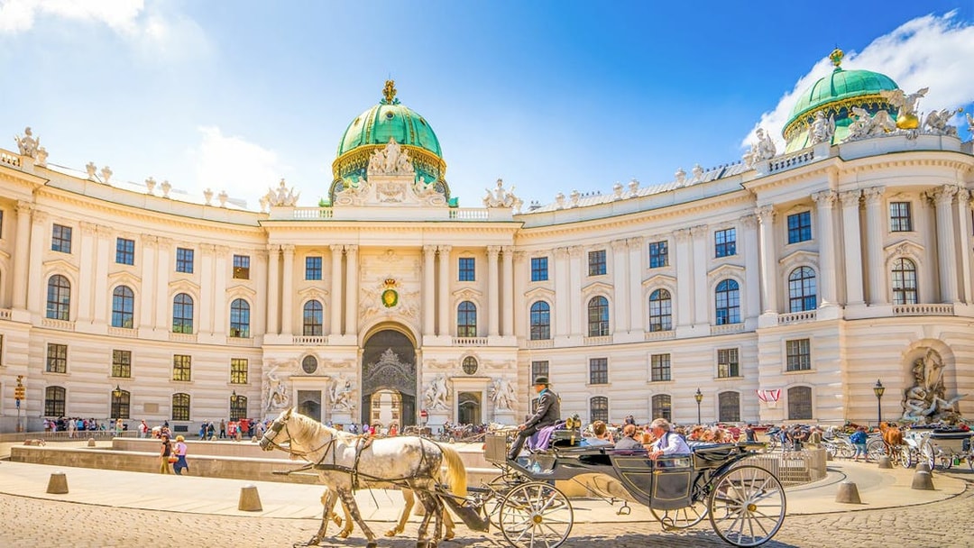 Hofburg Palace in Vienna with horse-drawn carriage, part of self-guided audio tour.