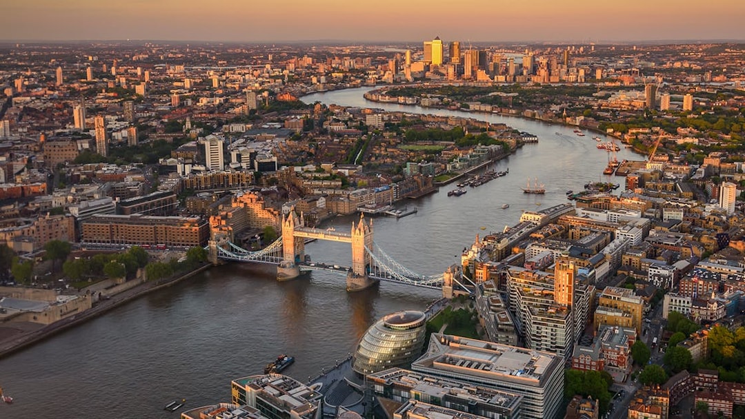 View of London from The Shard at sunset, featuring Tower Bridge and the Thames River.