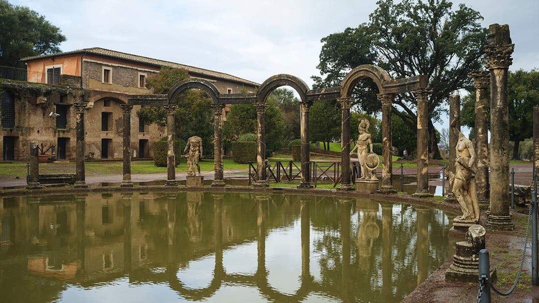 Tivoli's Villa Adriana reflecting pool with ancient statues and arches.
