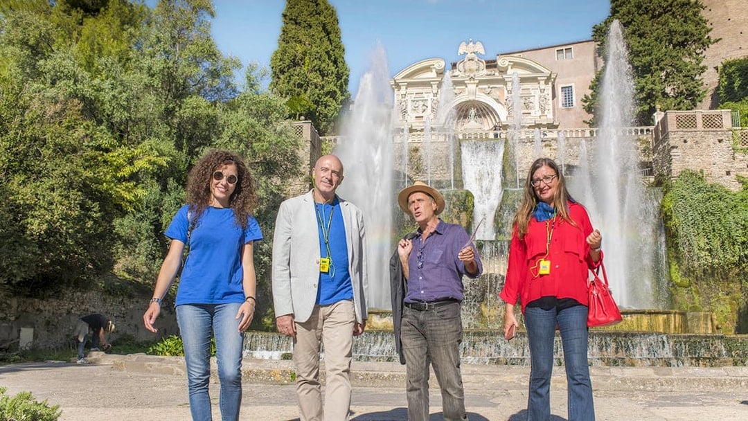 Tour guide with visitors at Tivoli Villa d'Este fountains in Italy.