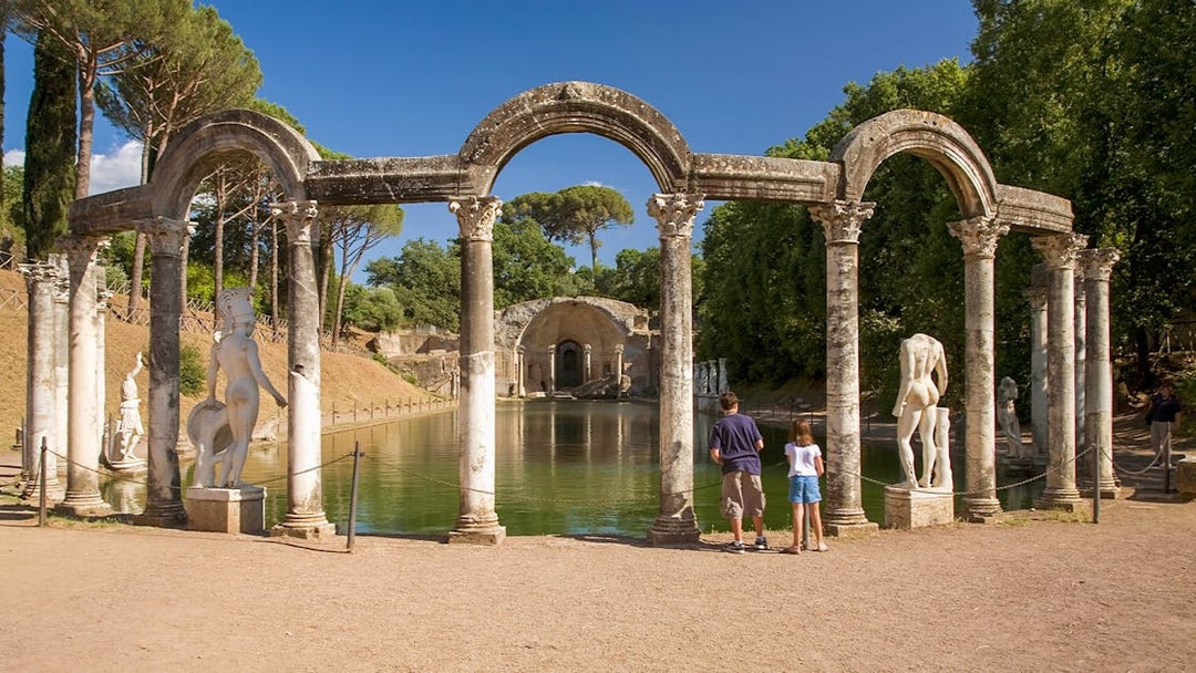 Statues and columns at the Canopus in Hadrian's Villa, Tivoli, with visitors observing.